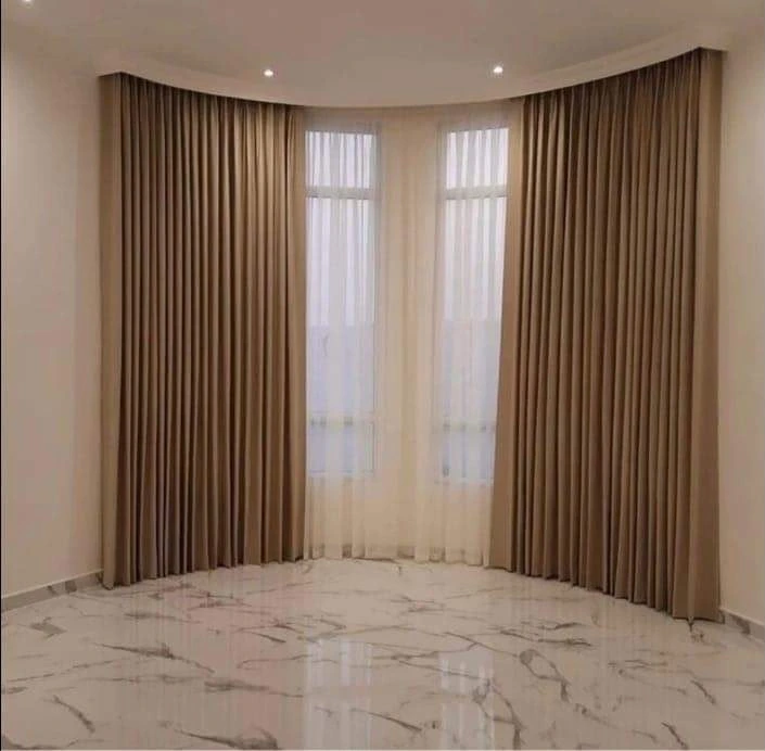 Wave curtains closed across a living room window in Doha